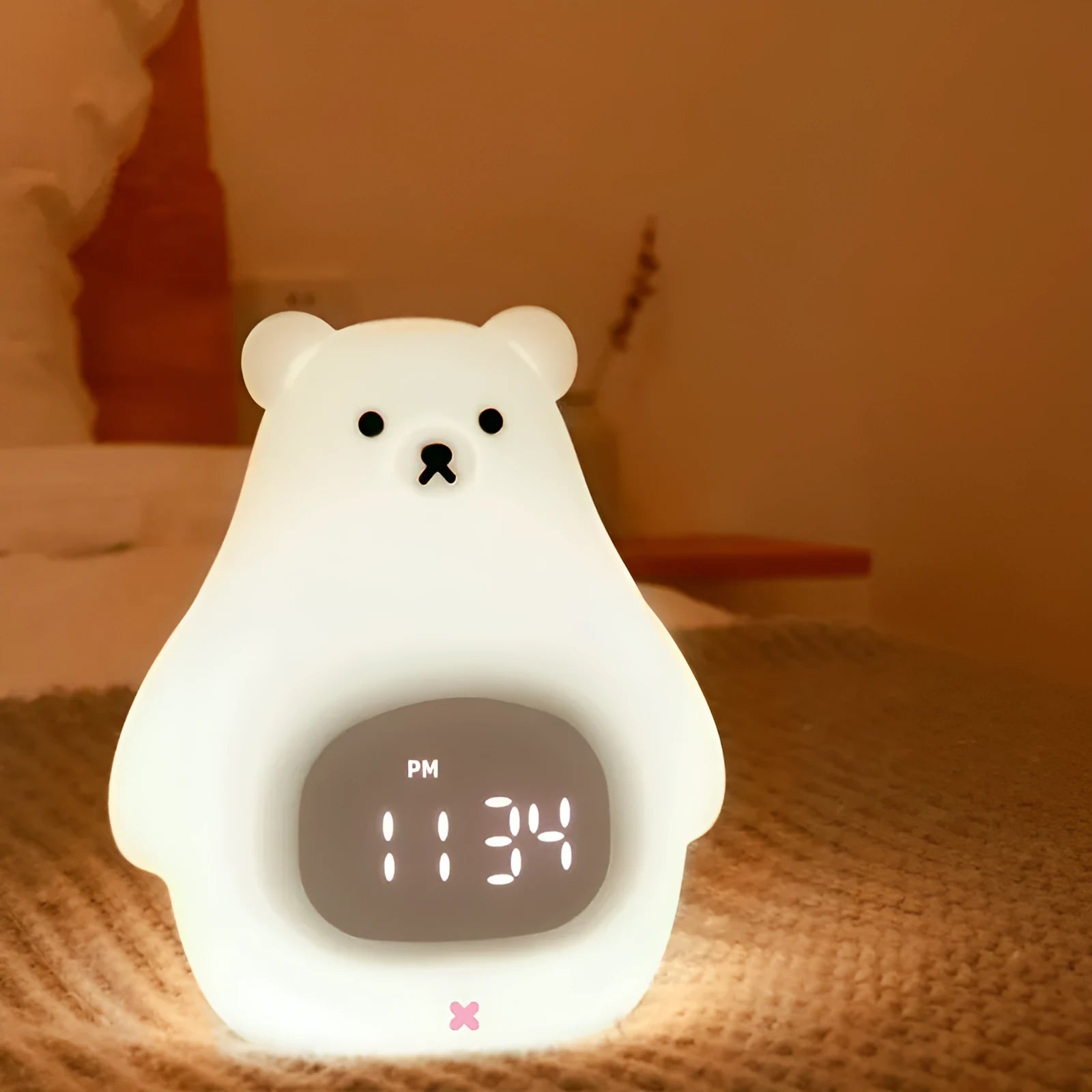 White silicone bear-shaped night light with button controls on a table.