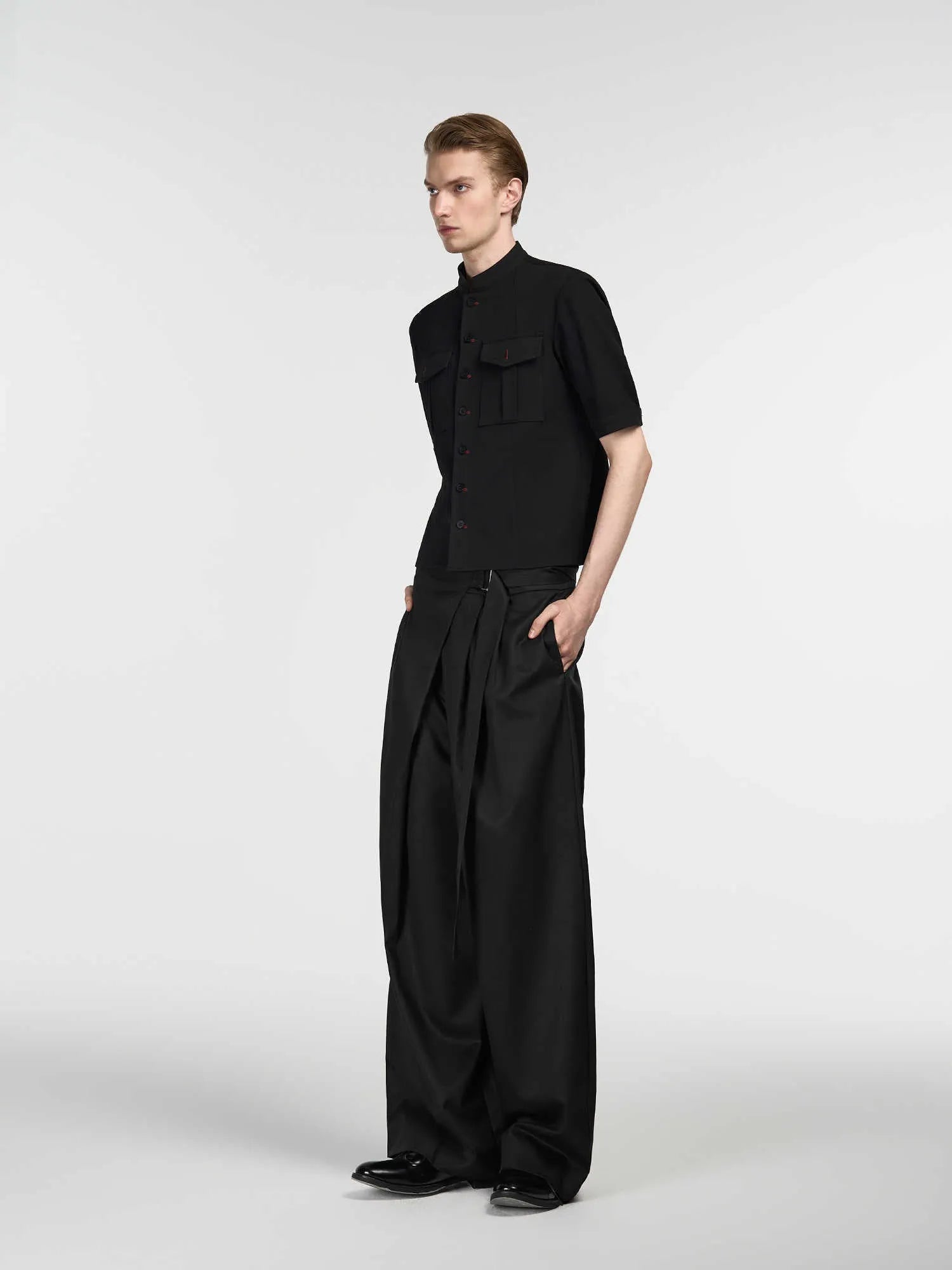 Black loose fit straight-leg trousers with single pleat front and adjustable waistband