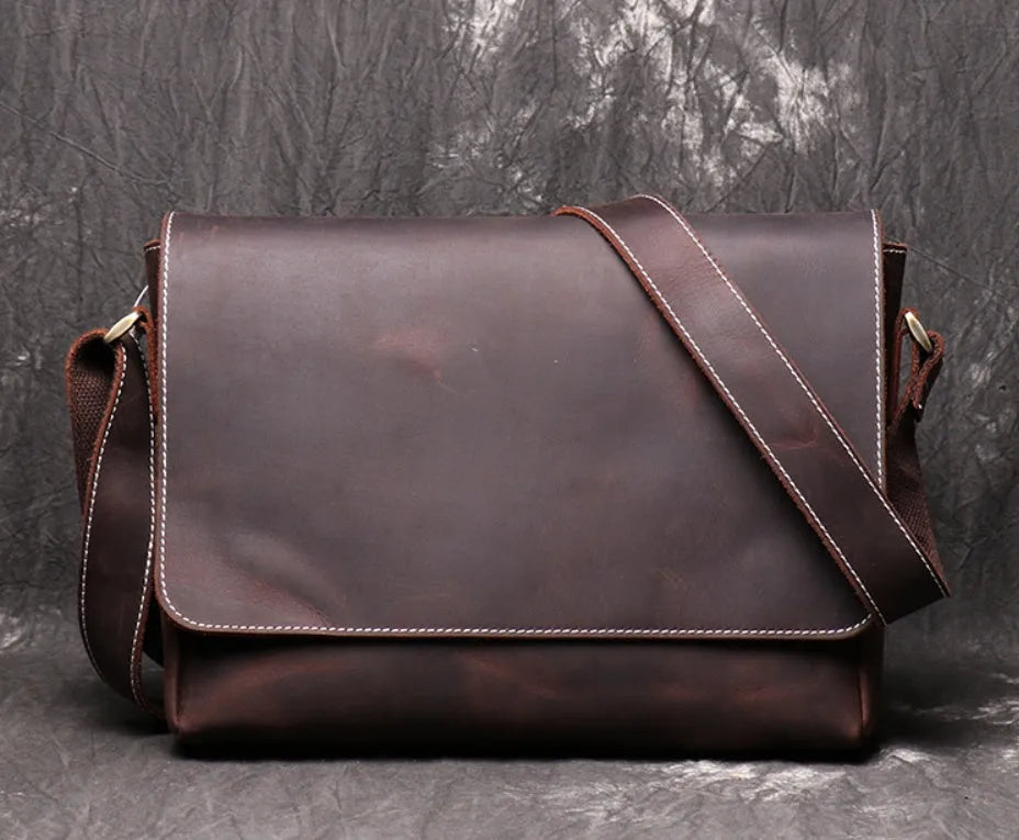 Vintage brown cowhide men's messenger bag showing front flap and adjustable shoulder strap