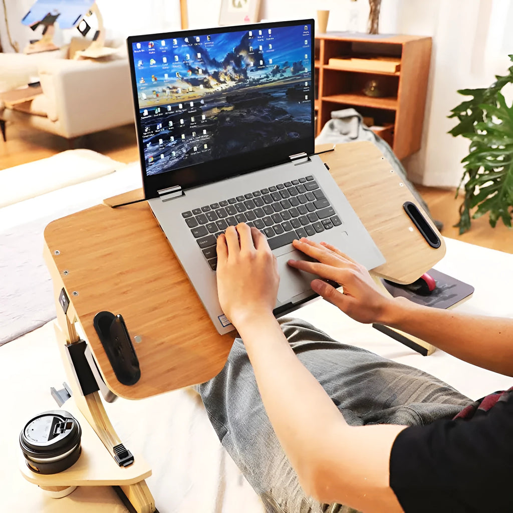 White maple wooden folding computer table with adjustable angle, set on a bed.
