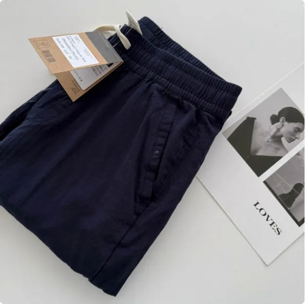 Man wearing beige loose straight-leg casual summer pants with a drawstring waist.