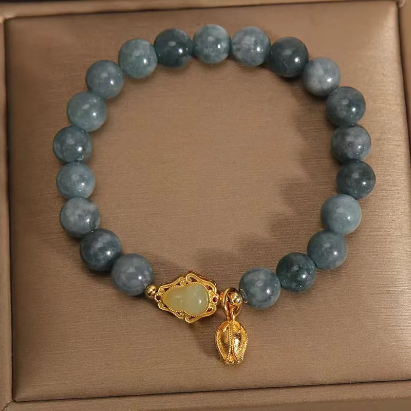 Natural stone bracelet with blue beads, lotus pendant, and adjustable leather strap