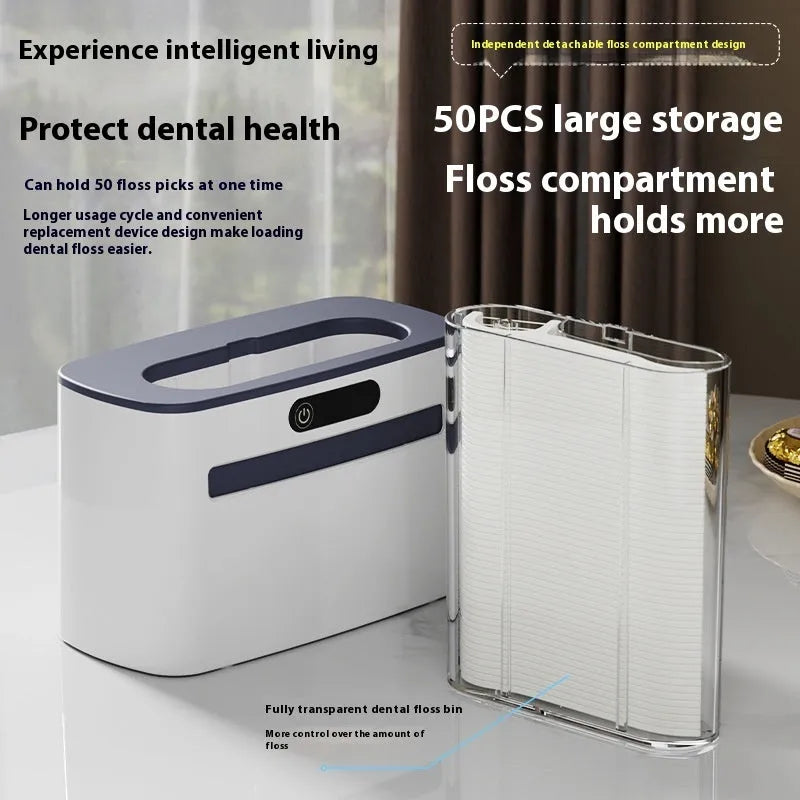 Dark gray automatic electric dental floss box with pop-up floss dispenser on a bathroom counter.