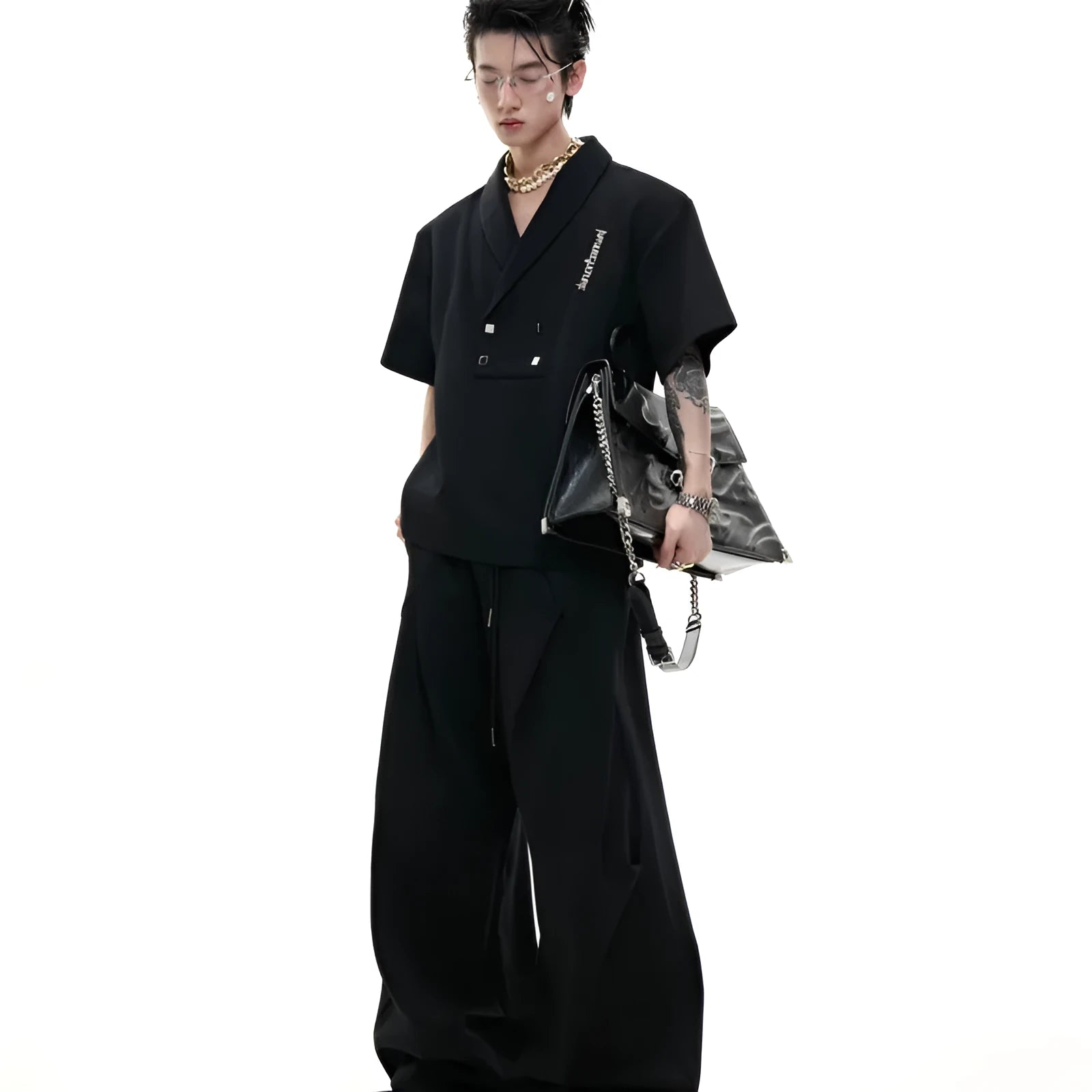 Men's dark grey cotton sports suit with V-neck short sleeve top, padded shoulders, metal embellishments, and matching shorts.