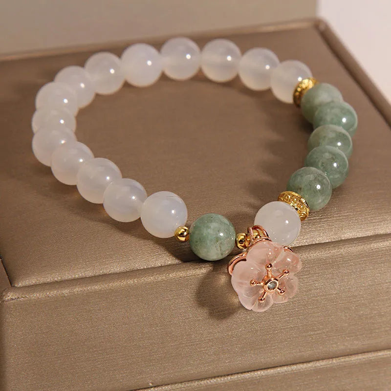 Jade floral bracelet with white agate jadeite stone and pink flower details on wrist