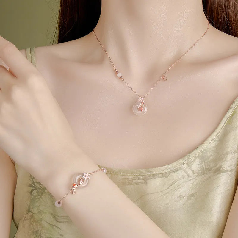 Close-up of a women's S925 sterling silver bracelet with a floral geometric shape, white chalcedony crystal, and a detailed Koi fish motif.