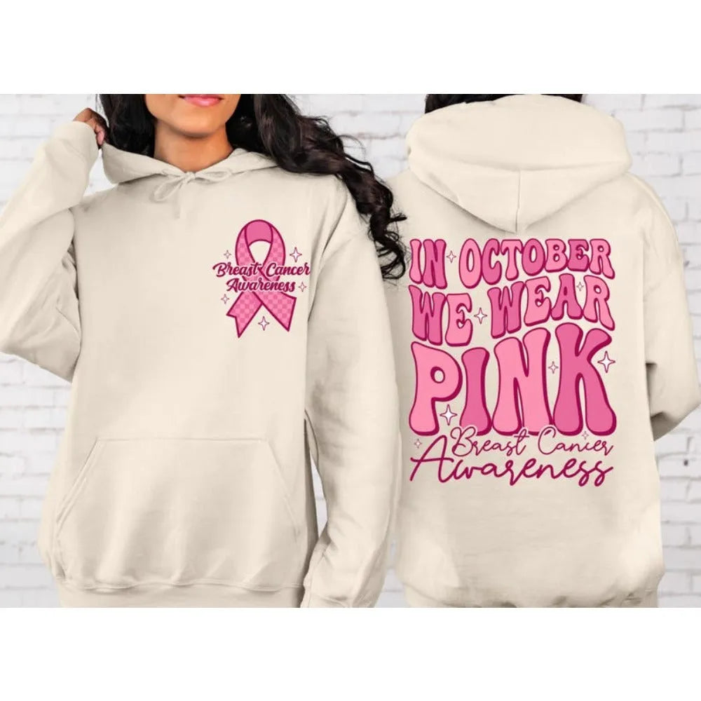 Pink breast cancer awareness hoodie with retro pattern and side pocket on a hanger.