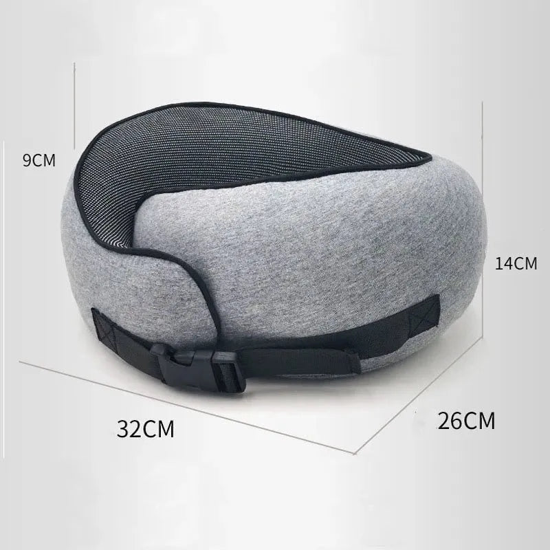 U-shaped navy blue memory foam travel neck pillow rolled up next to a mobile phone showing compact size