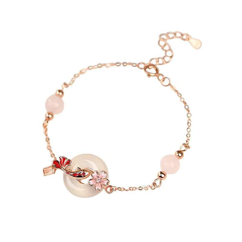 Close-up of a women's S925 sterling silver bracelet with a floral geometric shape, white chalcedony crystal, and a detailed Koi fish motif.