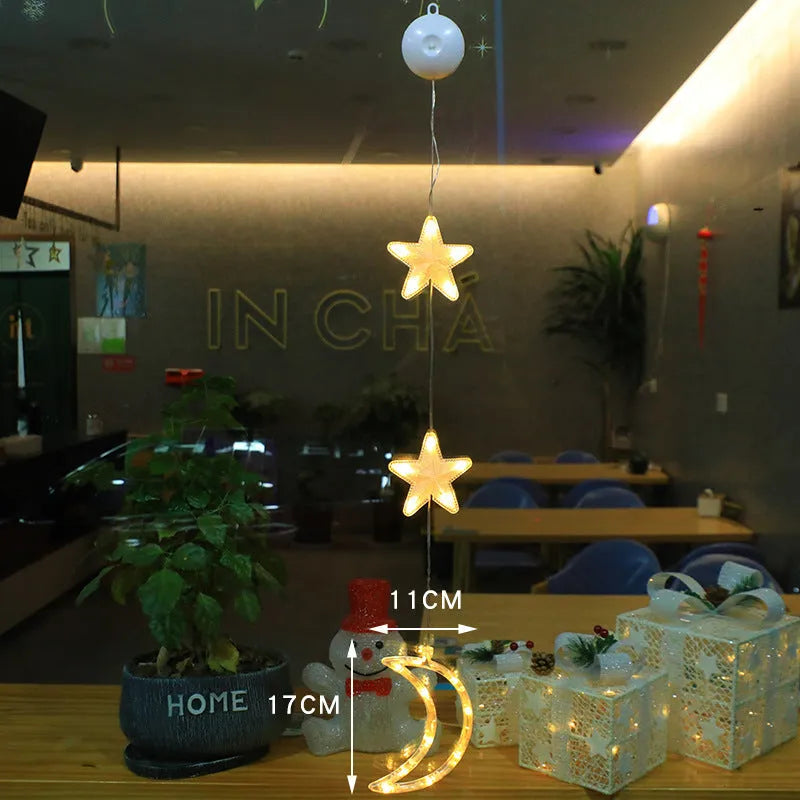 Three Christmas LED light ornaments with suction cups hanging on window