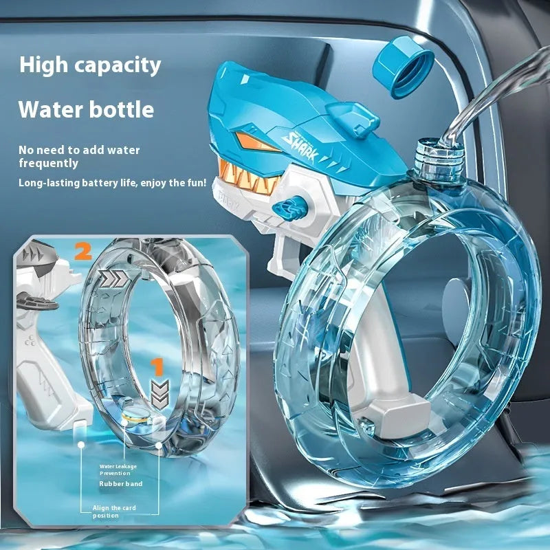 Blue Shark-shaped electric water gun toy with a large tank, placed on a sandy beach.