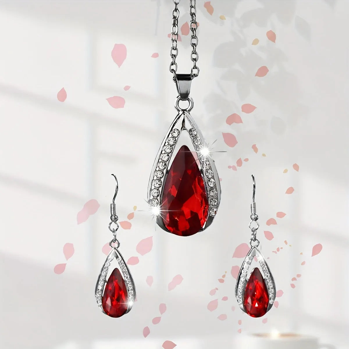 Black and red teardrop glass pendant necklace and matching earrings set on a white background.