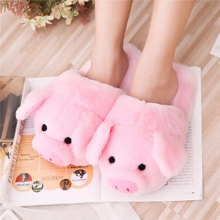 Pink pig-shaped plush floor slippers with soft filling on a plain background.