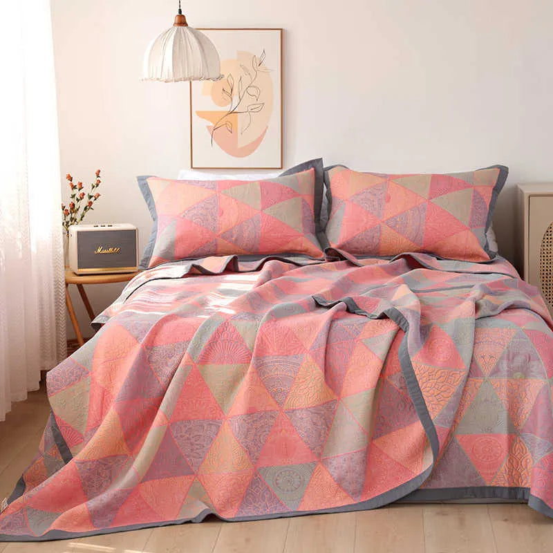 Cotton gauze bed blanket set with floral pattern and two matching pillowcases laid on a bed