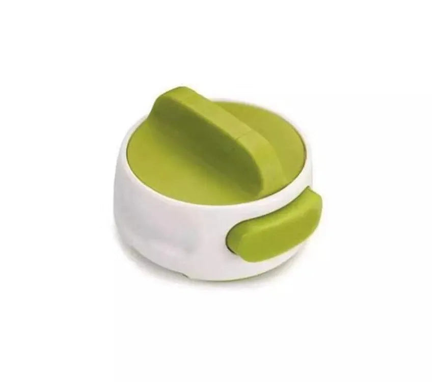 Green stainless steel bottle opener gadget for screw-top lids on a kitchen counter.