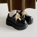 Matte black women's lace-up leather shoes with a thick sole and a chunky heel.