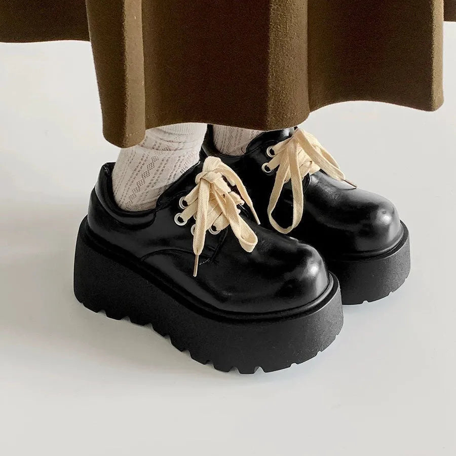 Matte black women's lace-up leather shoes with a thick sole and a chunky heel.