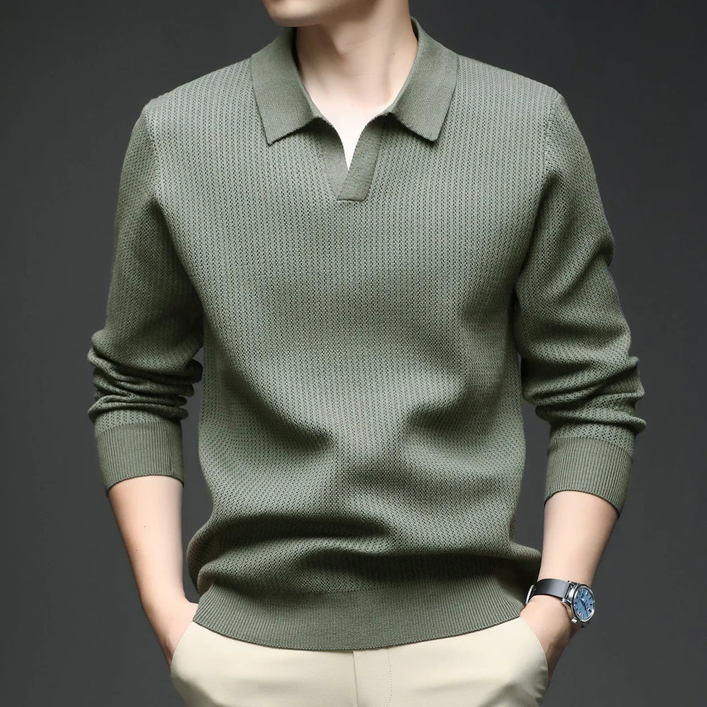 Man wearing a loose green casual pullover sweater, showing the simple long-sleeve design.