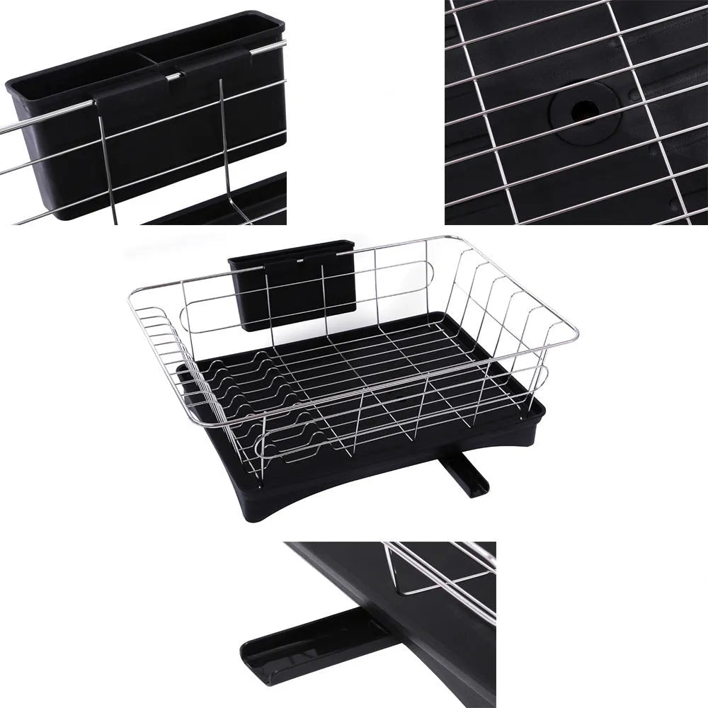Black stainless steel dish drying rack with plastic cutlery holder and drain board on a kitchen counter.