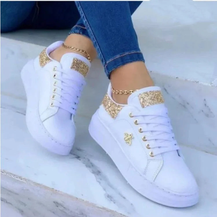 White low-top platform sneakers with lace-up closure and rubber sole on a light background