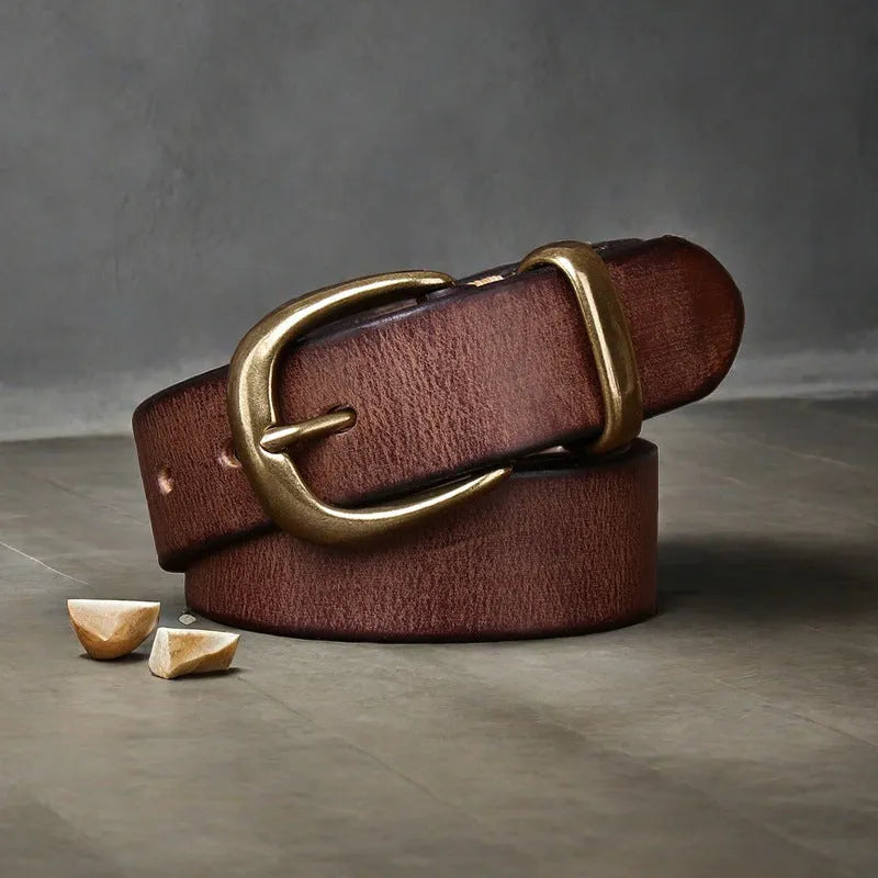 Men's black genuine cattlehide leather belt with a copper pin buckle on a jeans background