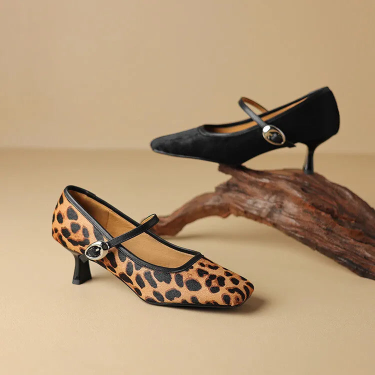 Women's black square toe stiletto heel ankle-strap shoes with horse hair upper on a plain background