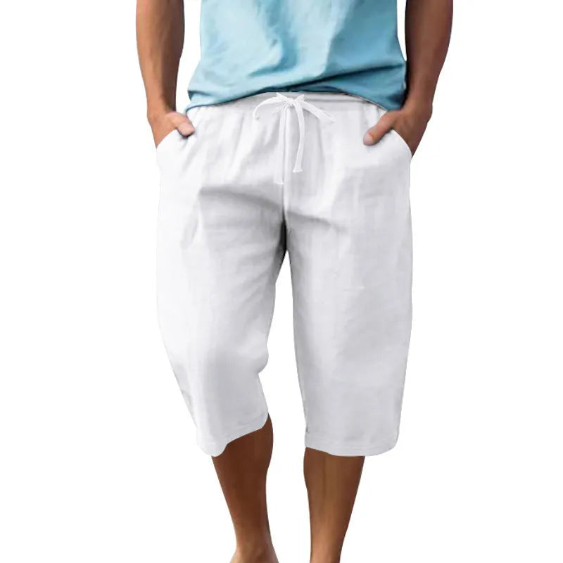 Men's light khaki linen shorts with a drawstring waistband and loose, cropped leg fit.