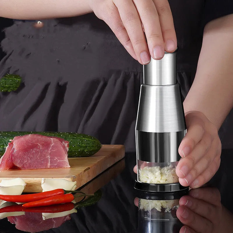 Manual garlic press and onion chopper kitchen gadget with stainless steel blades, shown in modern simplicity style.