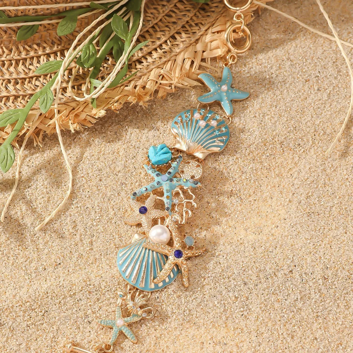 Alloy rhinestone bracelet with boat anchor, marine shell, and starfish charms in blue, red, or turquoise.