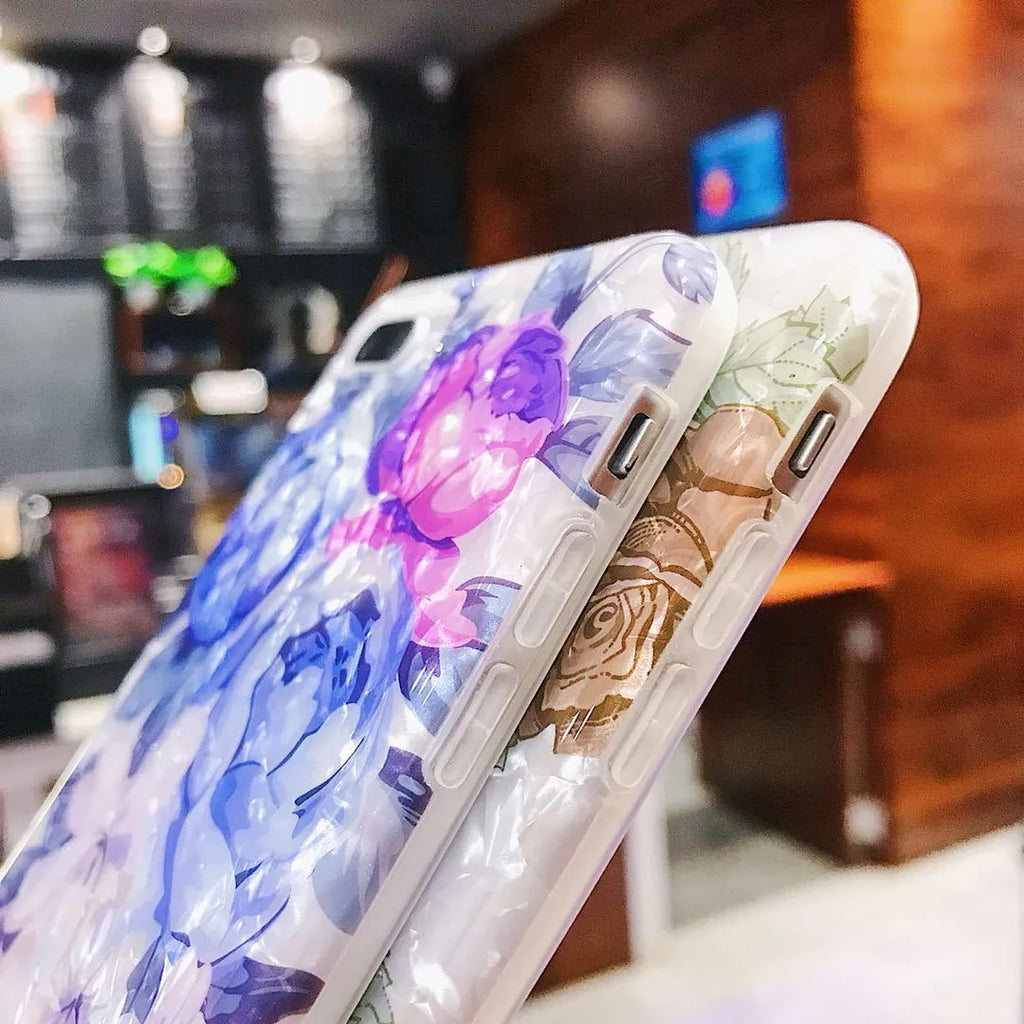 Dream Shell soft TPU iPhone case with rose flower pattern on back, shown in brown, purple and white.