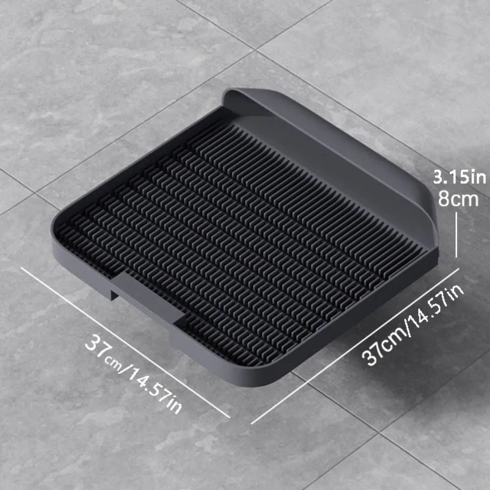 Large black cat litter pedal with slanted mouth and textured grooves beside a litter tray