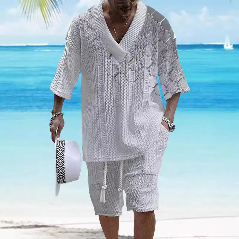 Man wearing a light blue printed drop-shoulder knitted top with matching shorts from a casual summer suit.