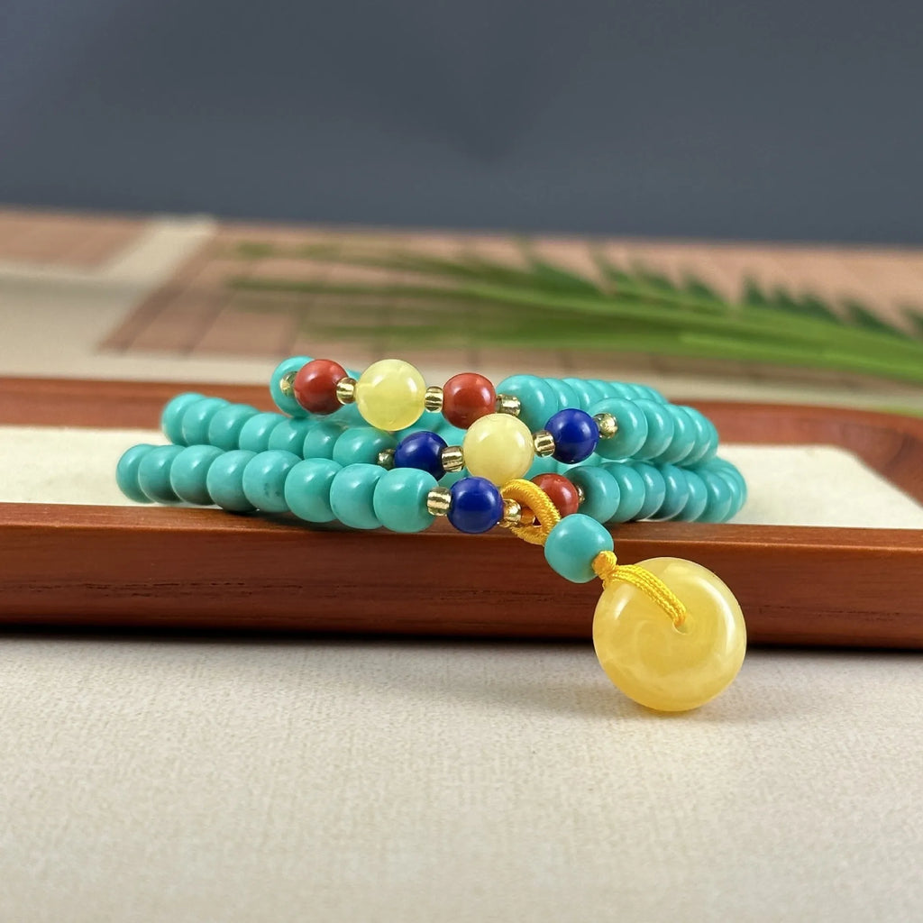 Hand-woven turquoise mesh flower pendant necklace on an adjustable ball bead chain.