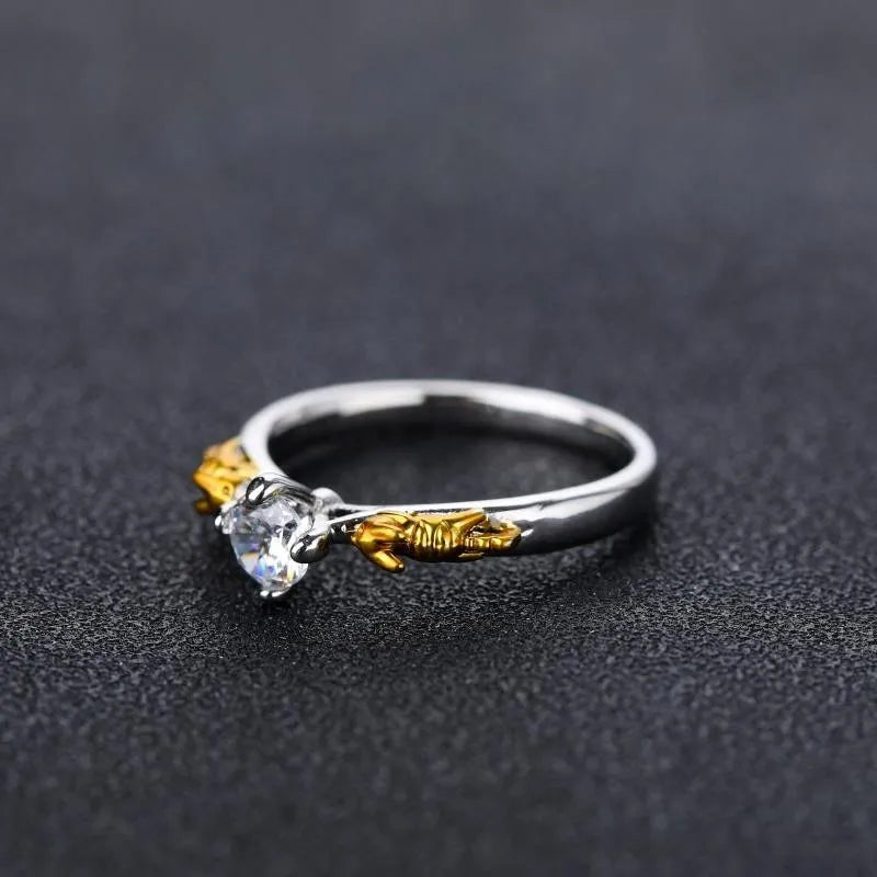 Copper crown-shaped crystal ring in a black gold tone on a neutral background.