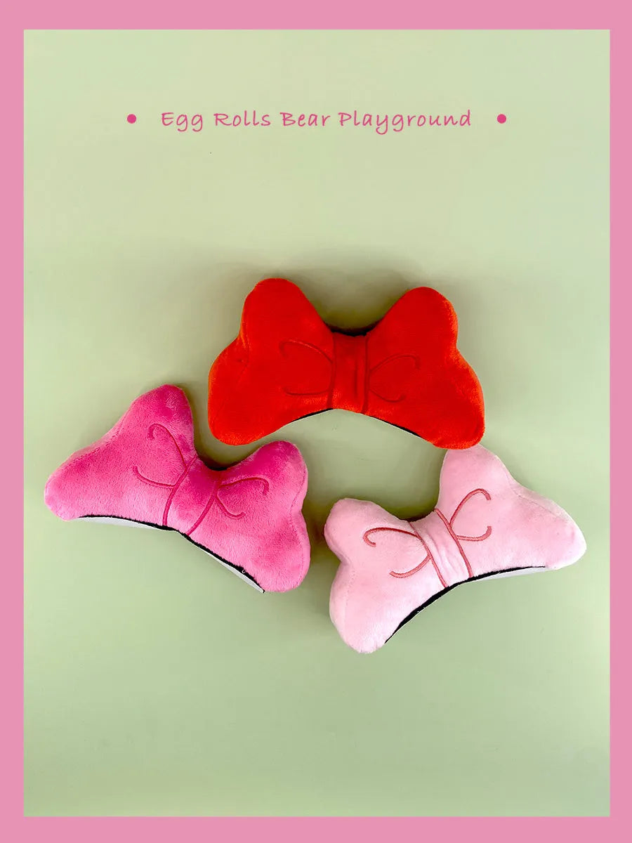 Plush bow tie helmet charm in red, peach pink and rose pink for clip-on decoration.