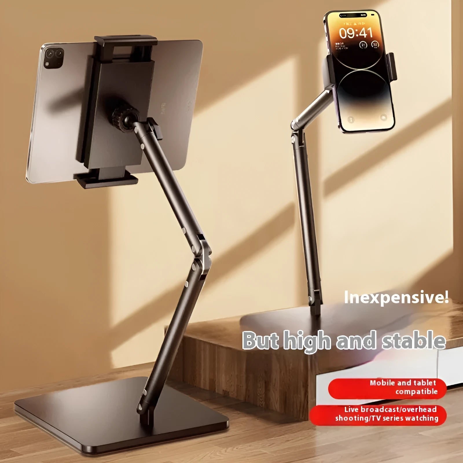 Silver alloy desktop phone bracket with double arms holding a smartphone, shown with a remote control on a wooden desk.