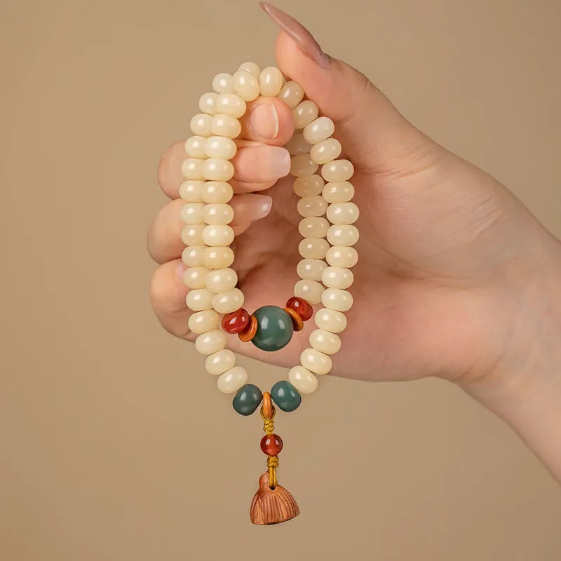 Cream topaz wooden bodhi root bracelet with flat round beads on a wrist.