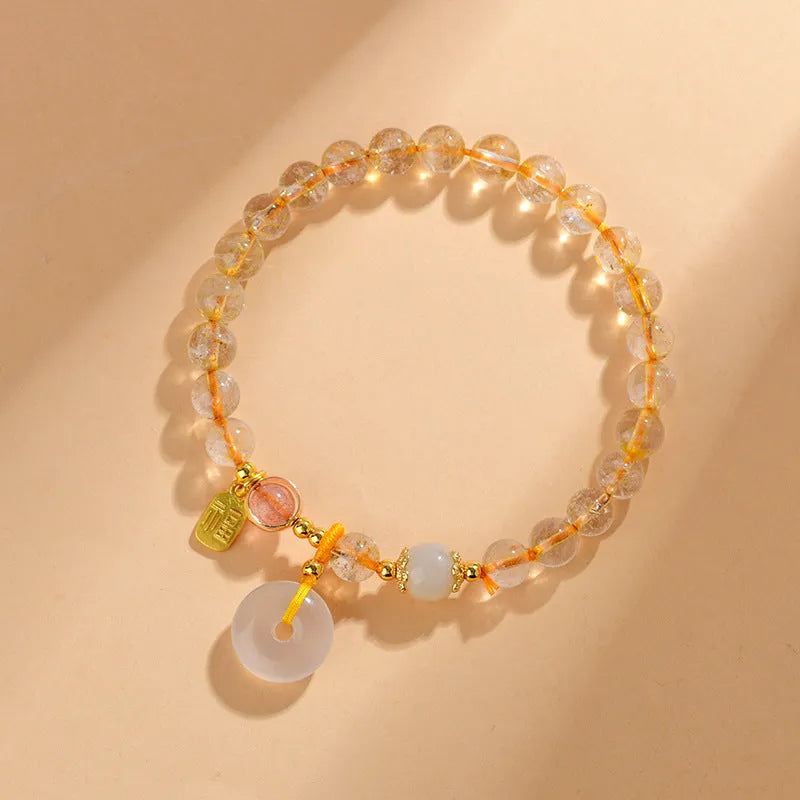 Gold rutilated quartz crystal bracelet with safety buckle and geometric national style design featuring blessing card pendant.