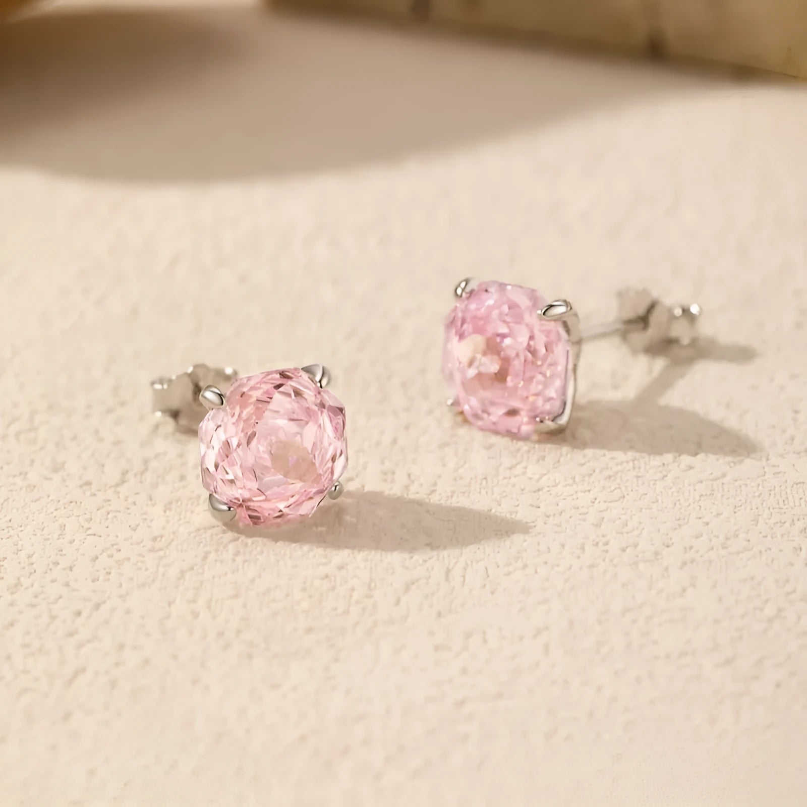 S925 sterling silver rose stud earrings for women in 6mm and 8mm sizes on a pink background.