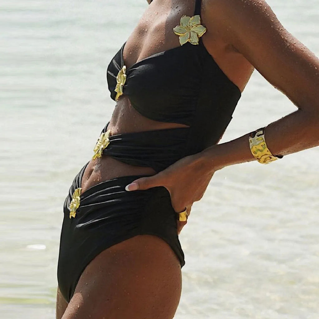 Women's solid colour one-piece swimsuit with hollow-out tube top and matching short skirt in black.