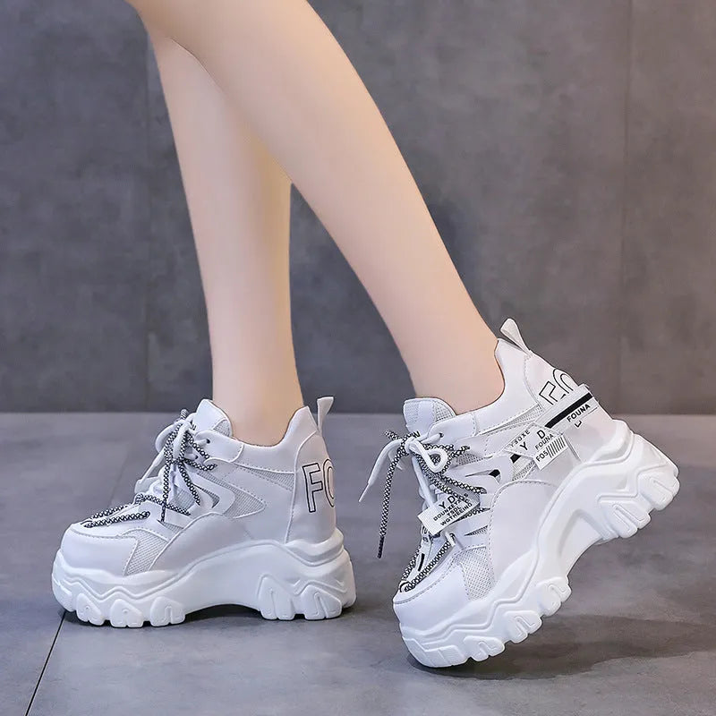 White women's platform sports shoes with mesh upper, cross strap, and a thick rubber sole.