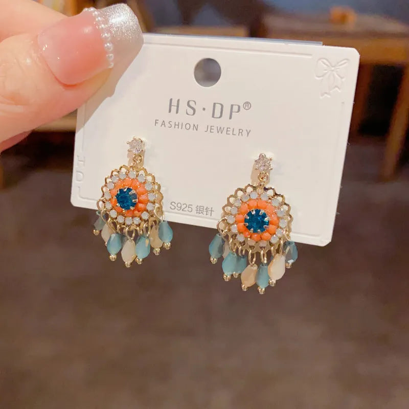 Round crystal tassel earrings with diamond embedded design and thick gold plating in blue or purple colour options
