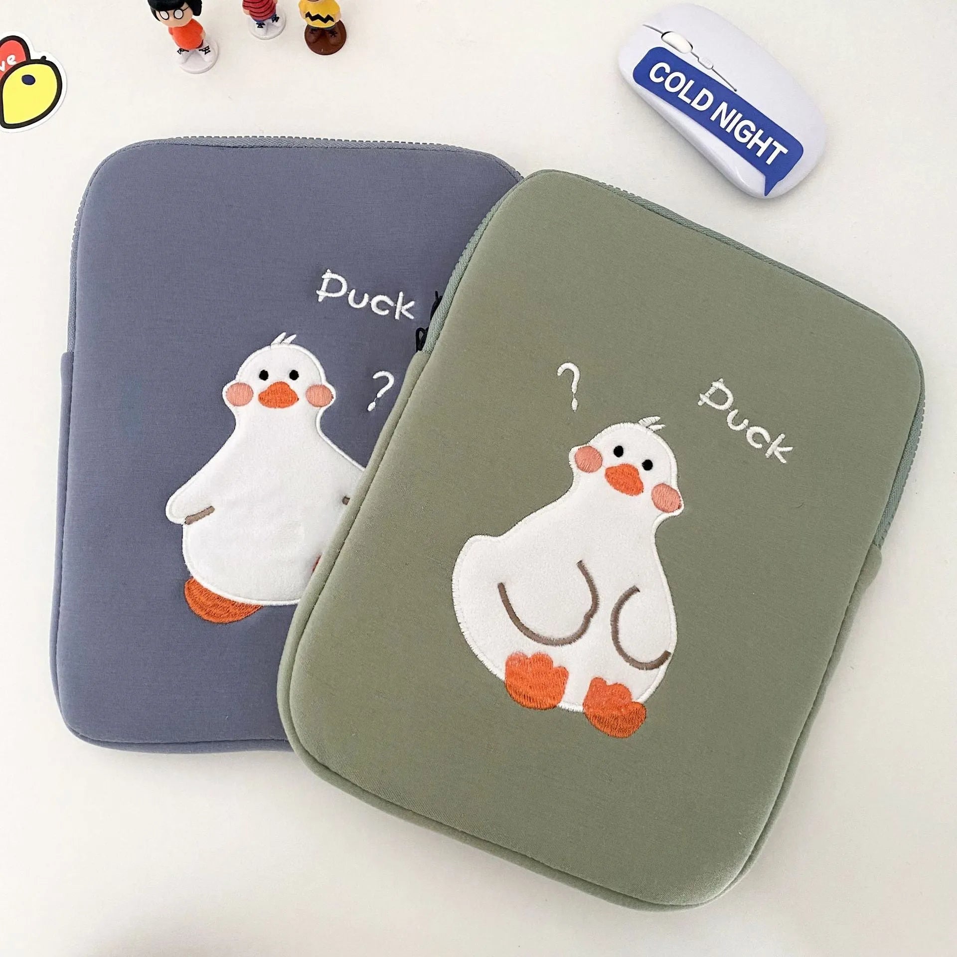 Blue cotton tablet case with embroidered cartoon duck design and a silver zipper.