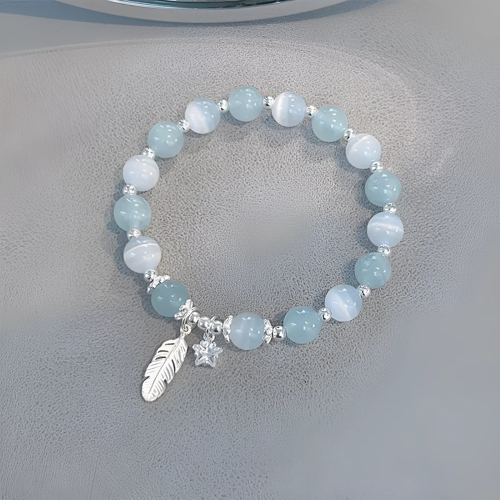 Korean style blue crystal bracelet with white lettering and a star charm on a wrist.