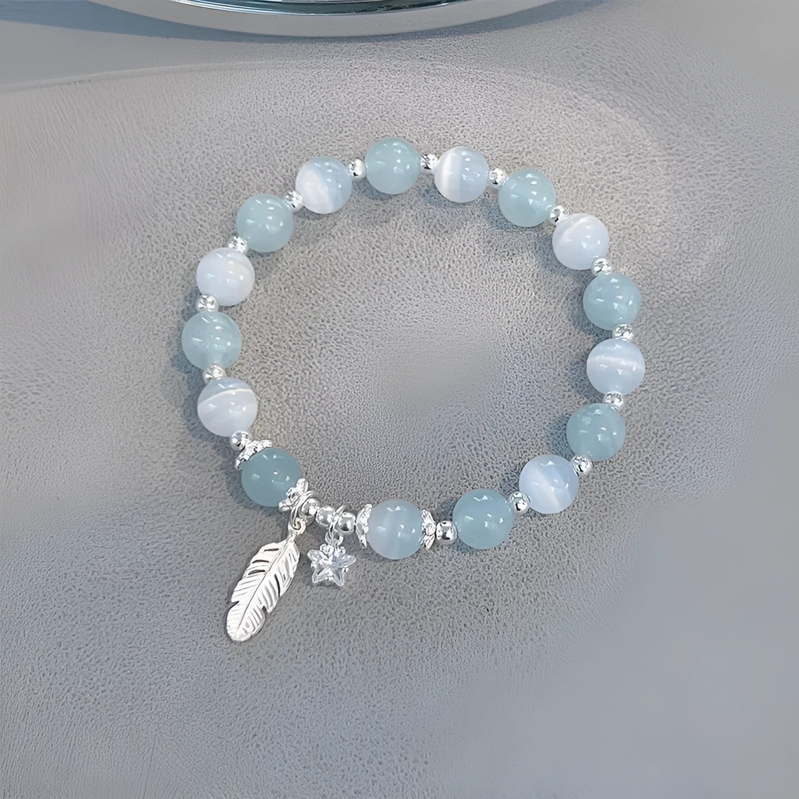 Korean style blue crystal bracelet with white lettering and a star charm on a wrist.