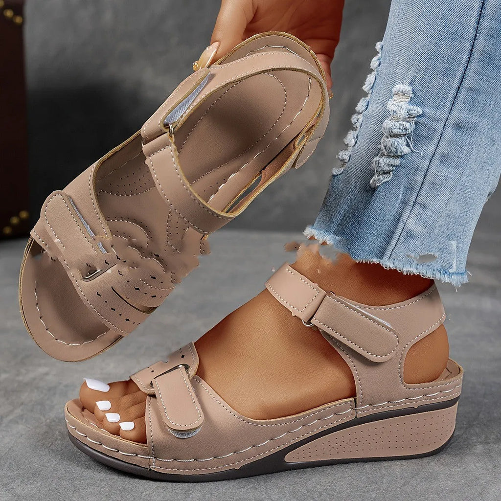 Women's beige strap sandals with a Velcro fastener and thick composite sole, shown in a round toe design.