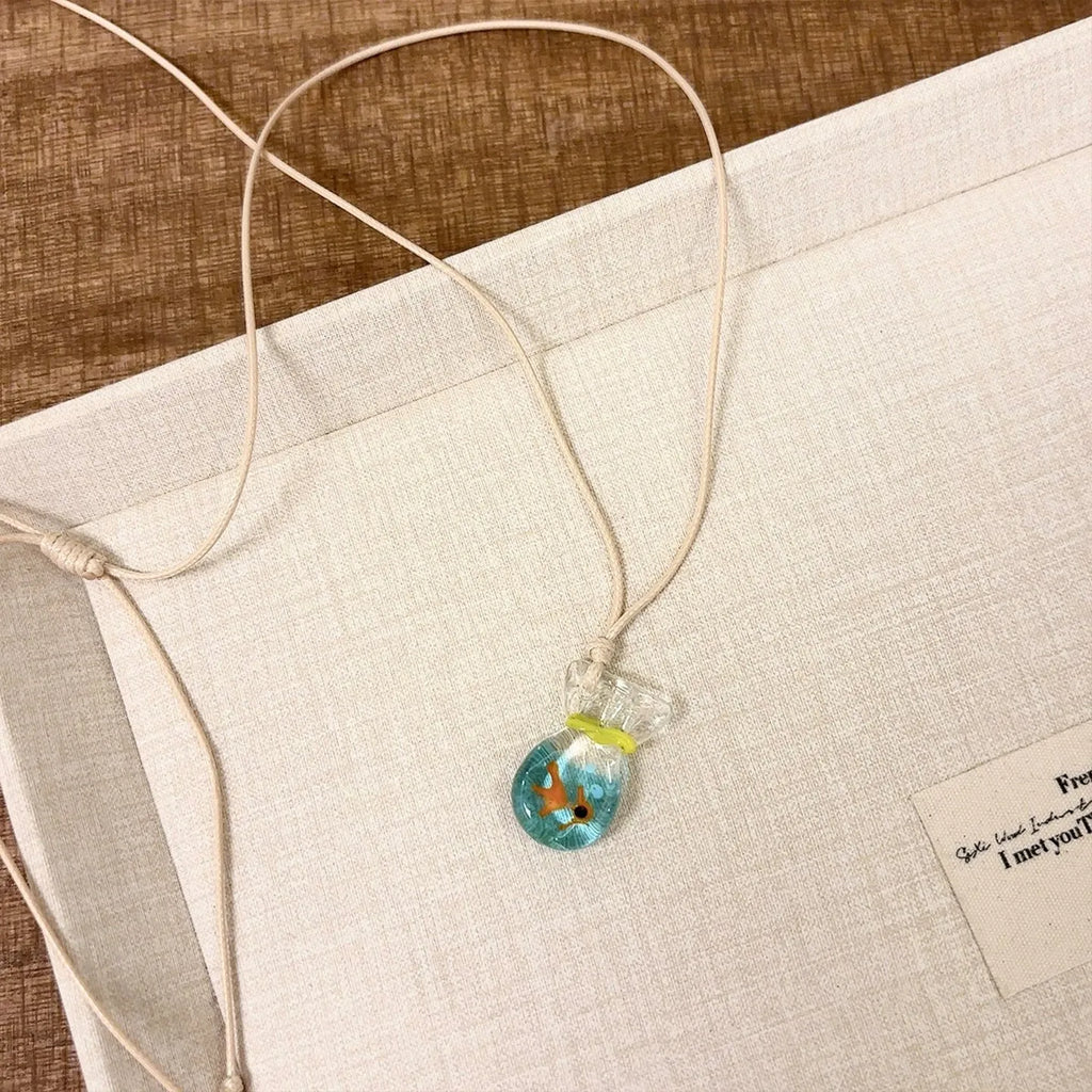 Women's necklace with coloured glaze joker charm on a cotton and linen clavicle chain