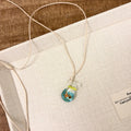 Women's necklace with coloured glaze joker charm on a cotton and linen clavicle chain