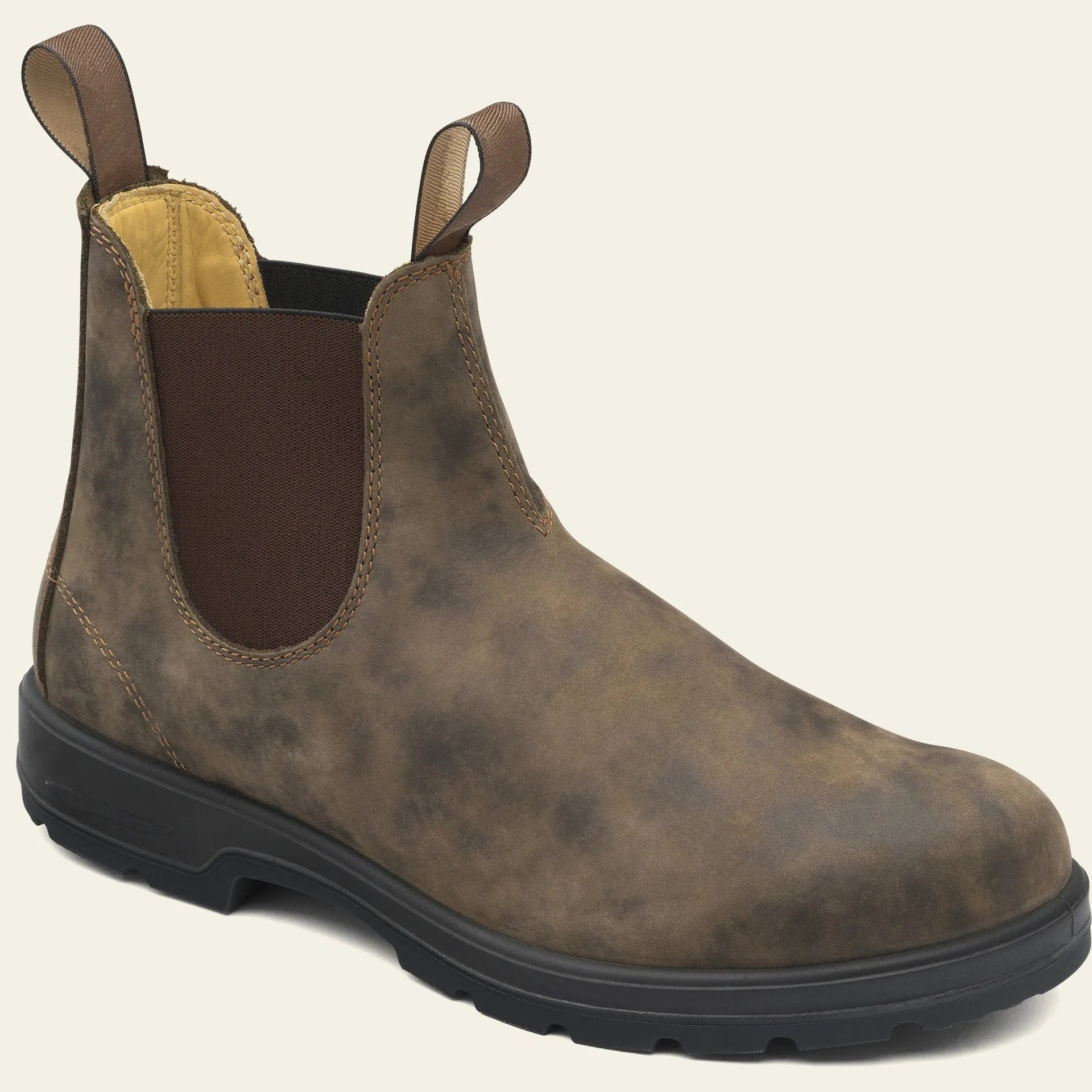 Vintage brown unisex Chelsea boots with round toe and low horseshoe heel on a wooden floor.