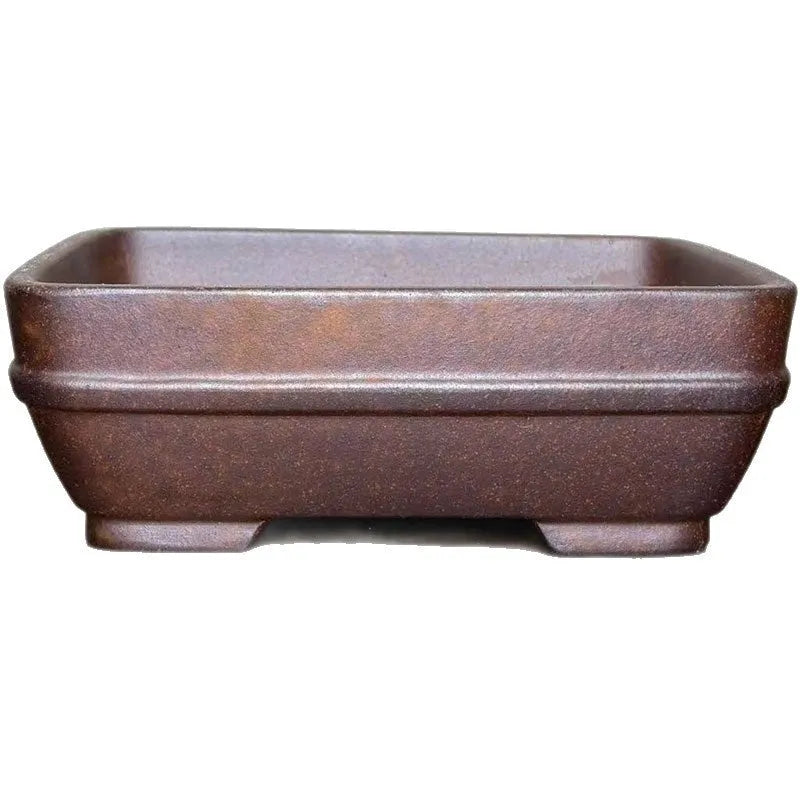 Light brown rectangular ceramic bonsai flower pot on a wooden surface